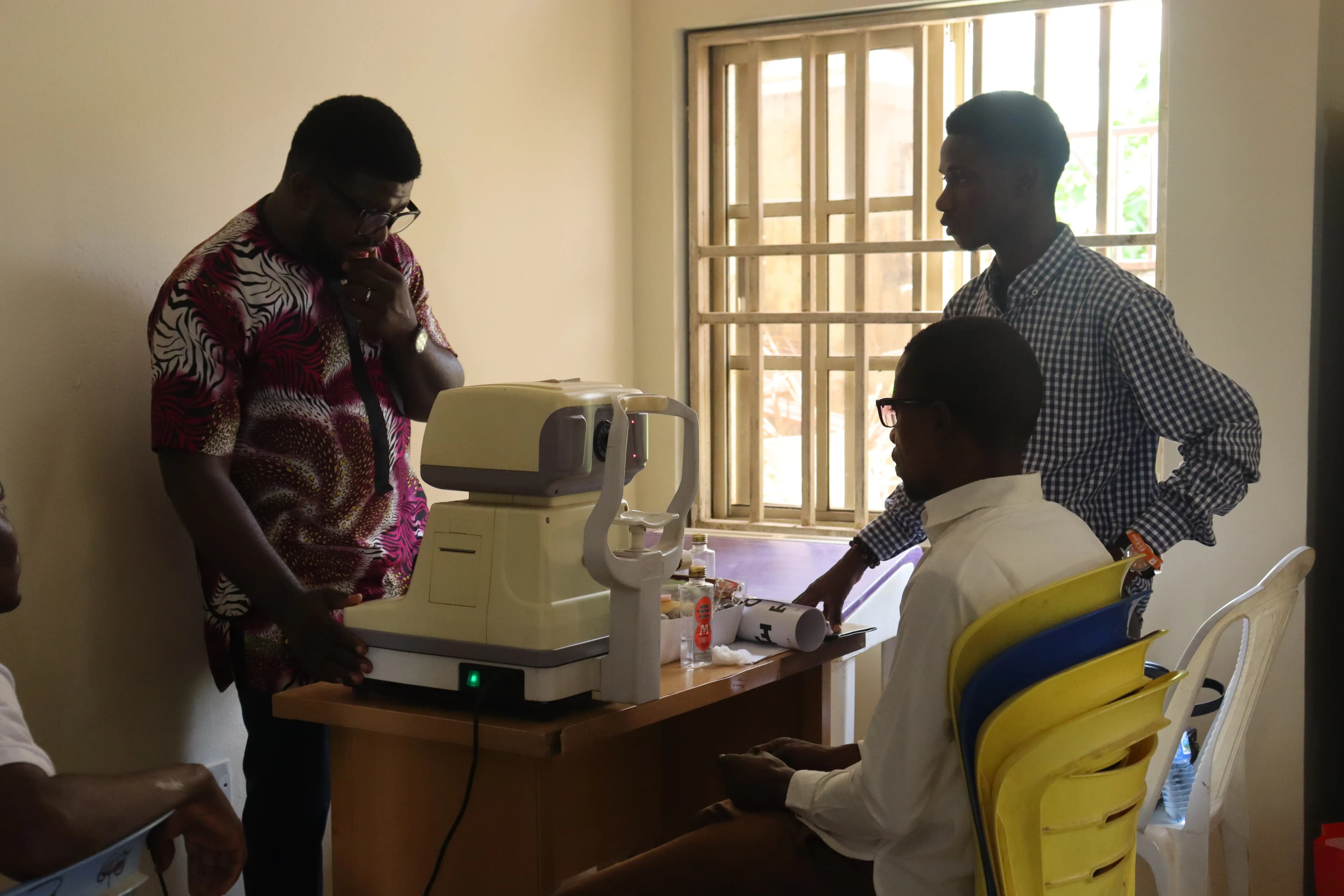 An optometrist uses a specialized optical machine to examine a patient's eyes