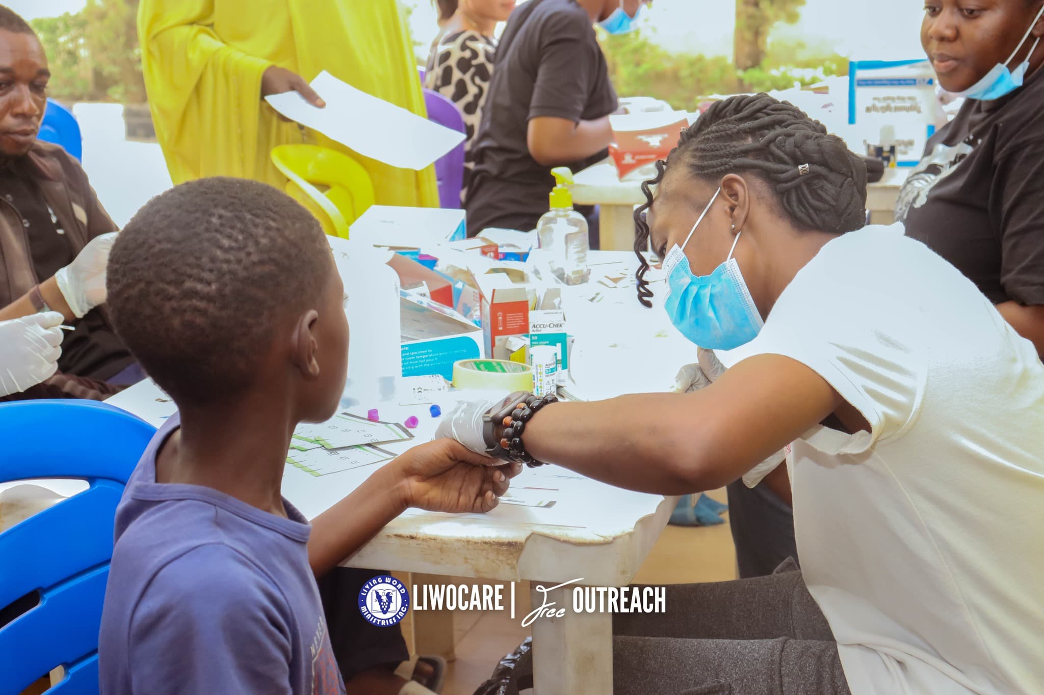 A little boy at a table being attended to by a medical personnel